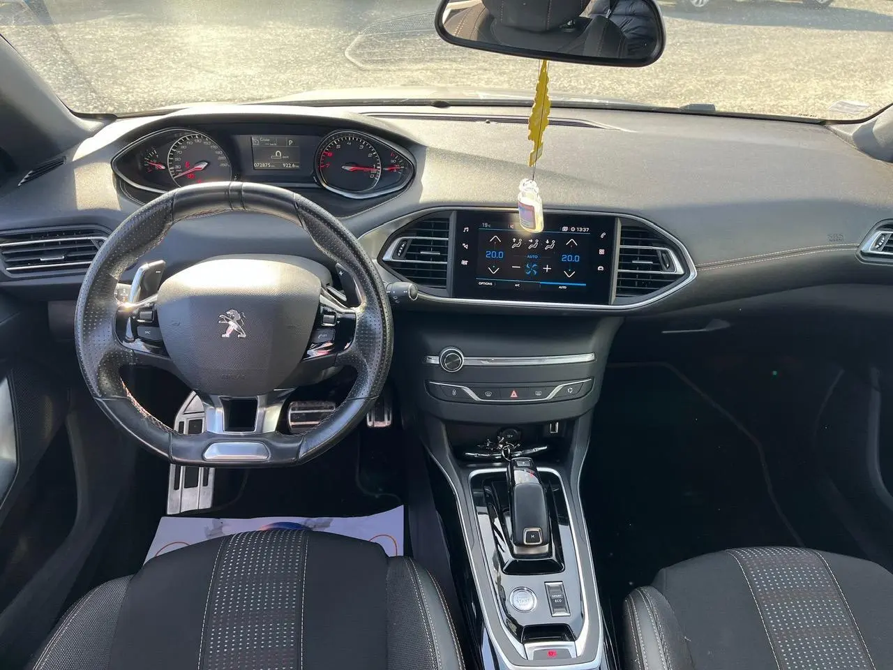 Intérieur Peugeot 308 SW gris clair, vue frontale du poste de conduite avec volant compact et écran tactile central.