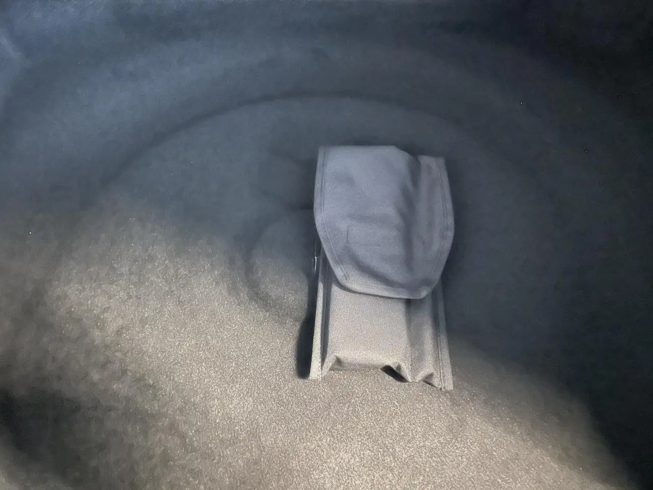 Gros plan sur le rangement intégré dans le coffre du Peugeot 3008 blanc Okenite, version hybride GT 2025.