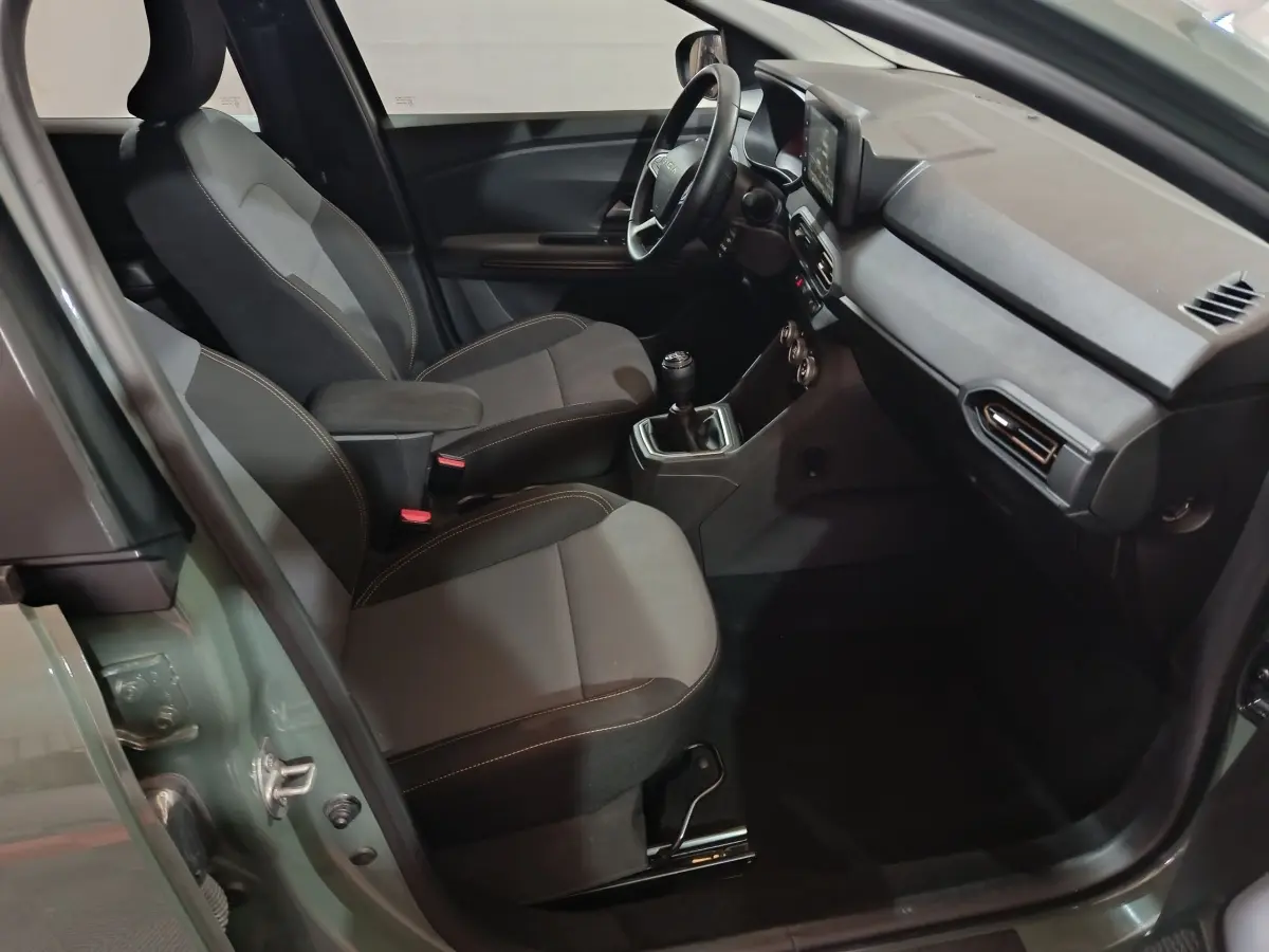 Vue intérieure côté conducteur de la Dacia Sandero Extreme+ TCe 110 2024, sièges gris et volant cuir noir.