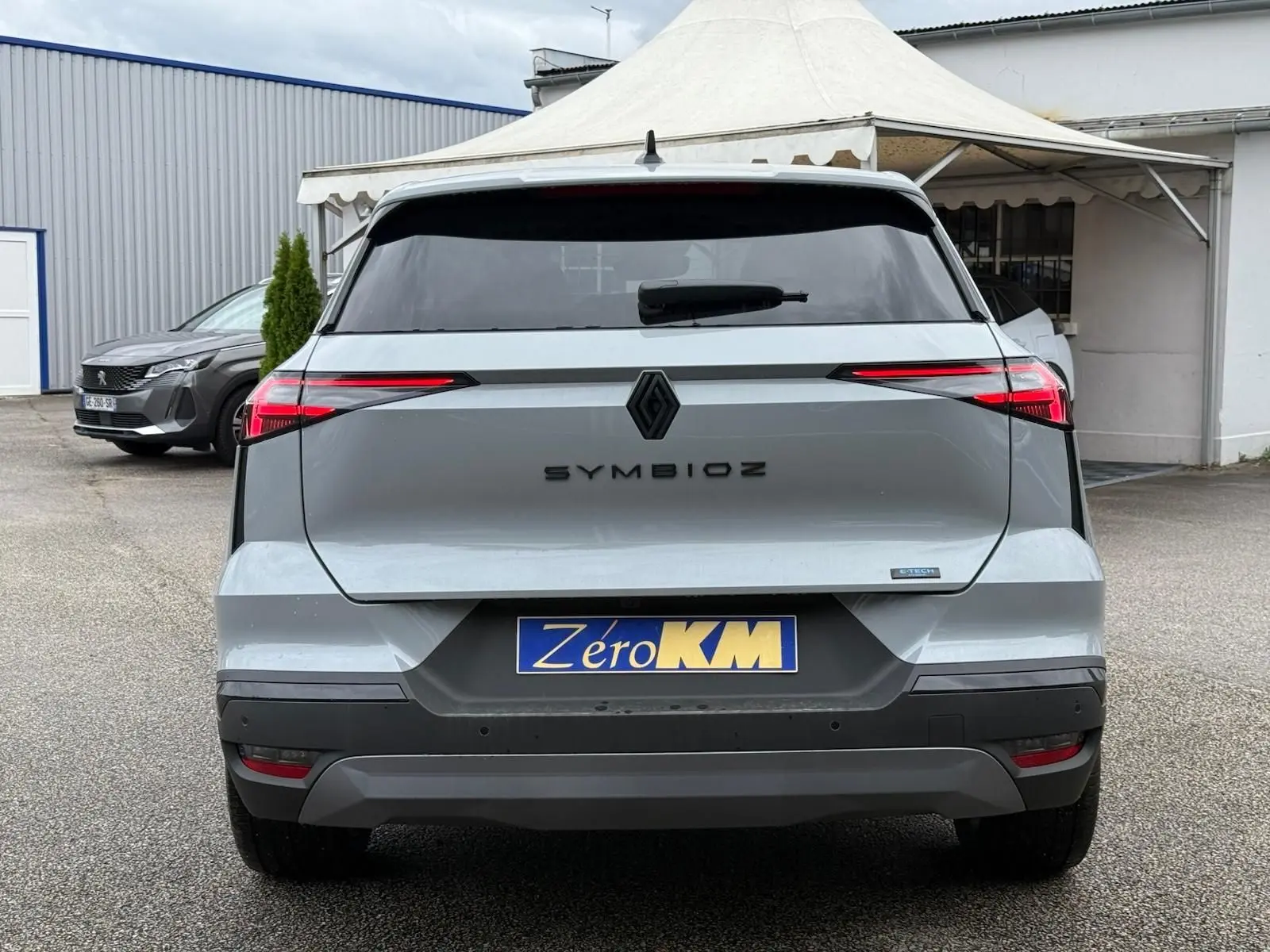 Vue arrière d'un Renault Symbioz gris Rafale 2026 avec feux LED fins et logo central noir brillant.