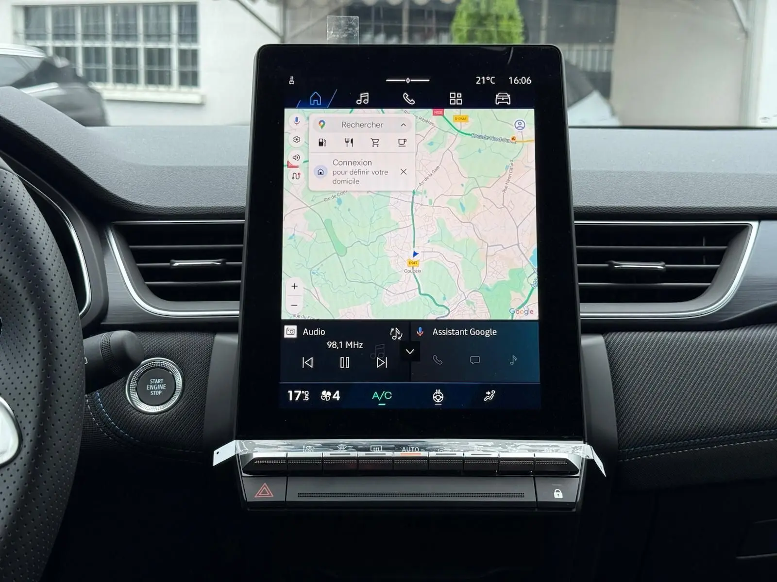 Vue intérieure centrée sur l'écran tactile vertical du tableau de bord du Renault Symbioz gris Rafale avec commandes climatisation.