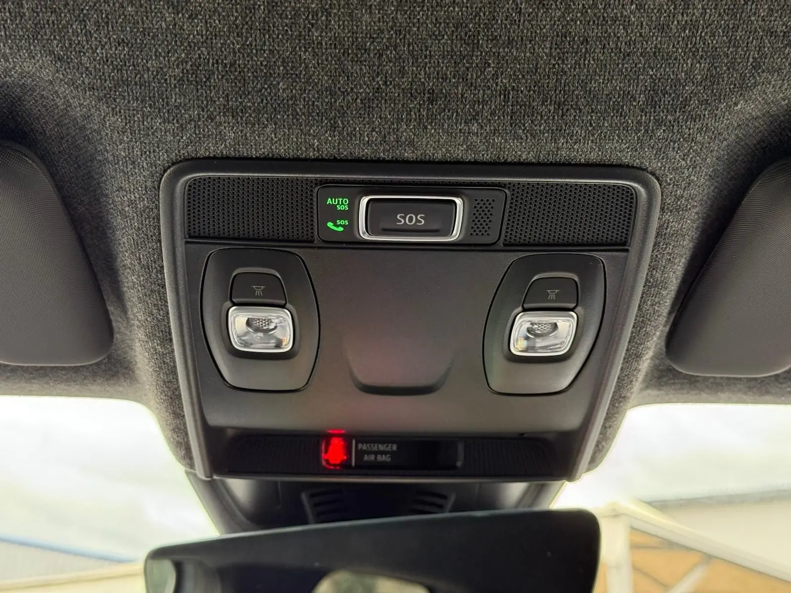 Gros plan sur la console de toit intérieure du Renault Symbioz gris Rafale, avec boutons SOS et éclairages intégrés.