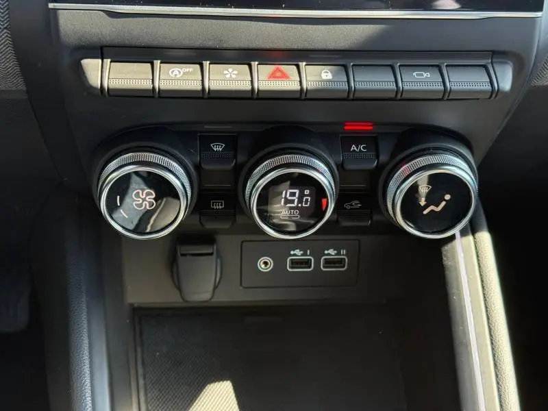 Gros plan sur les commandes de climatisation et les ports USB du tableau de bord d'une Renault Clio 2025.