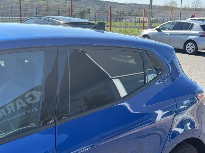 Vue latérale droite sur la partie arrière d'une Renault Clio 2025 Bleu Iron avec vitres teintées et antenne requin.