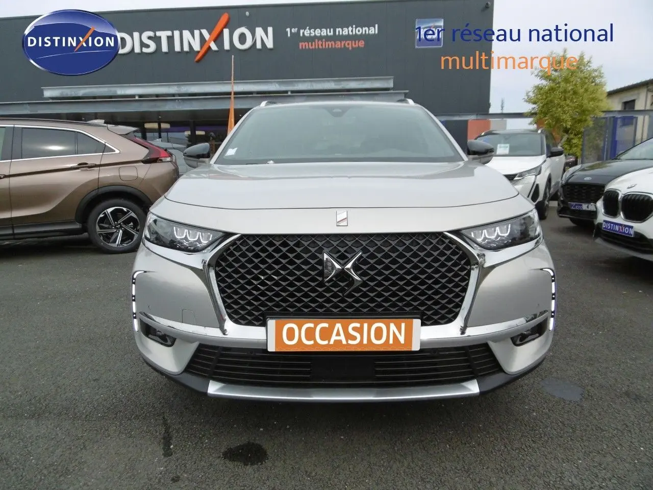 Vue frontale d'un DS7 Crossback hybride rechargeable Crystal Pearl avec calandre noire et feux LED distinctifs.