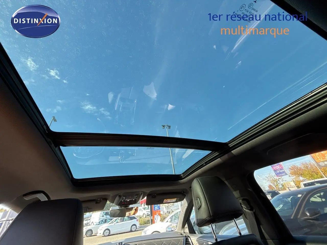 Toit panoramique en verre vu de l'intérieur arrière du DS7 Crossback E-TENSE 2021 avec ciel bleu visible.