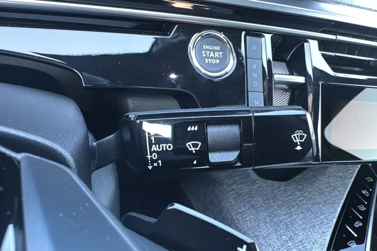 Gros plan sur la commande d’essuie-glace et le bouton start du tableau de bord du Peugeot 3008 noir perla nera 2025.