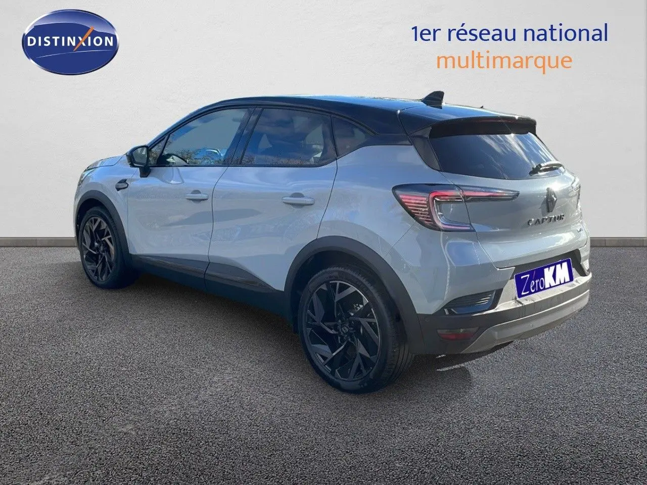 Vue 3/4 arrière droite d'un Renault Captur E-Tech hybride gris Rafale avec toit noir et jantes noires.