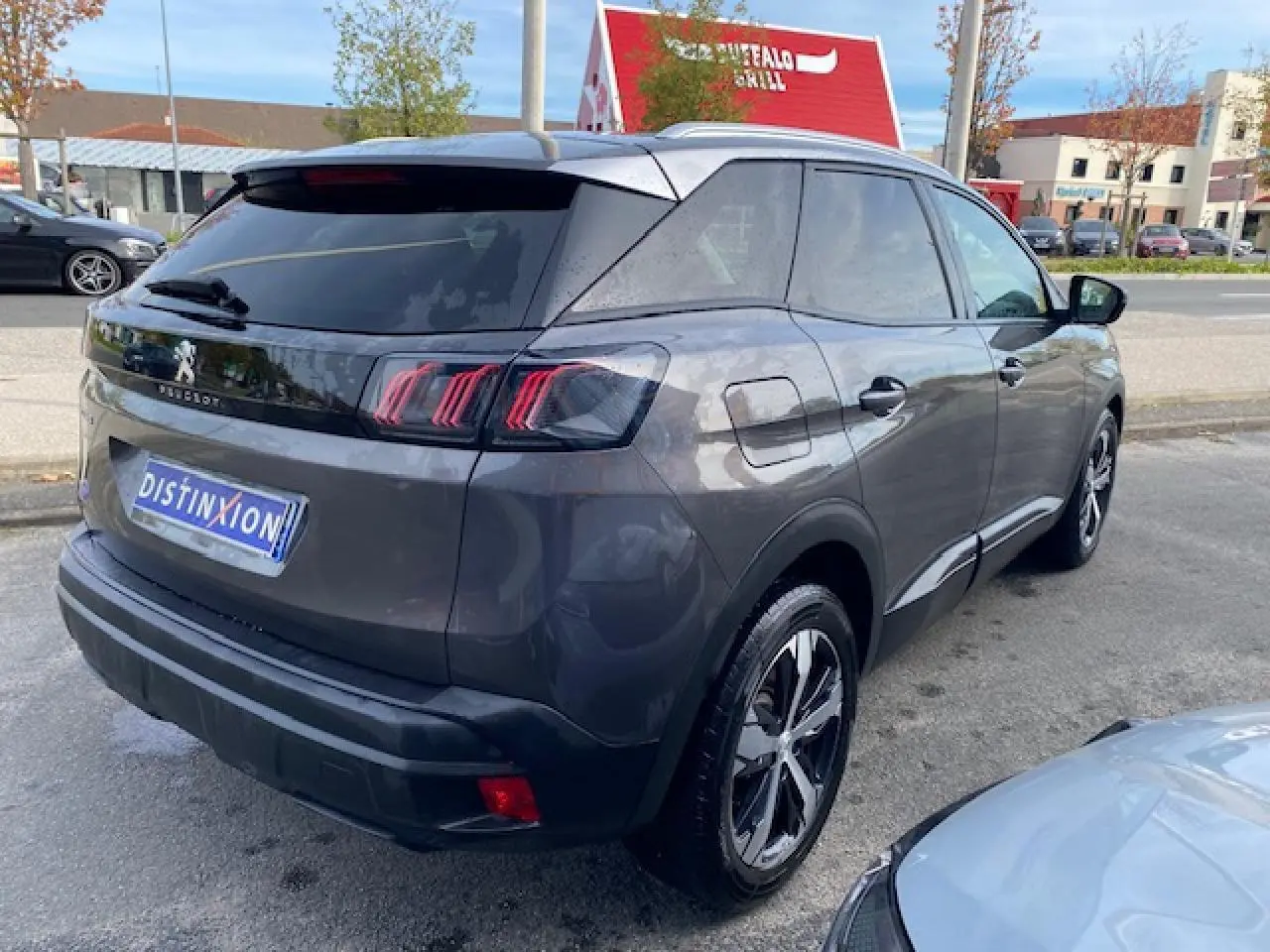 Vue 3/4 arrière droite d'un Peugeot 3008 gris platinium avec jantes alliage bi-ton et vitres surteintées.