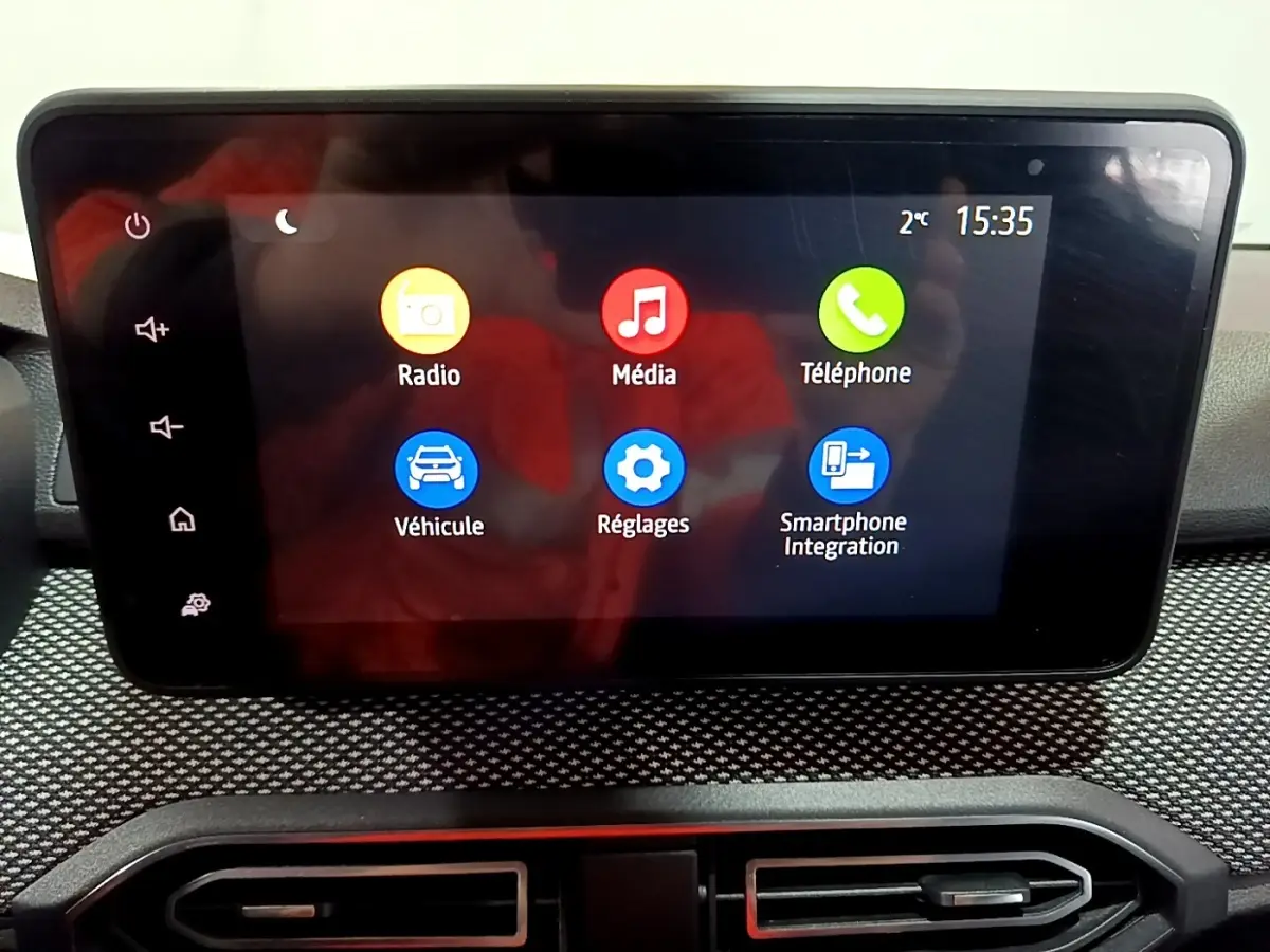 Écran tactile central de la Dacia Sandero blanc 2022 affichant les menus Radio, Média, Téléphone, Véhicule, Réglages et Smartphone Integration.