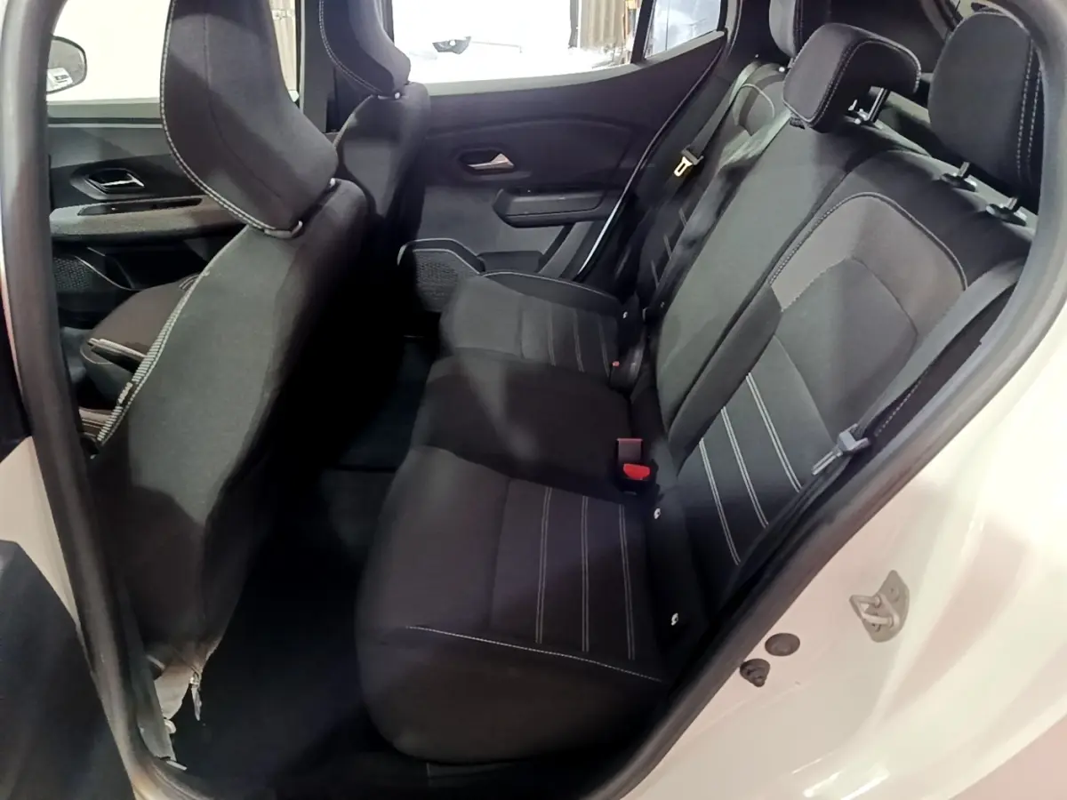 Vue intérieure côté droit sur la banquette arrière noire avec surpiqûres blanches d'une Dacia Sandero blanc 2022.