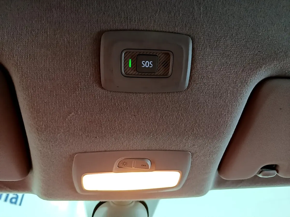 Vue intérieure du plafond avant d'une Dacia Sandero blanc 2022, avec bouton SOS et éclairage intérieur allumé.