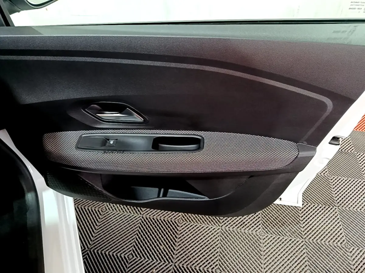 Vue intérieure de la porte avant gauche blanche d'une Dacia Sandero 2022, avec poignée argentée et habillage noir texturé.
