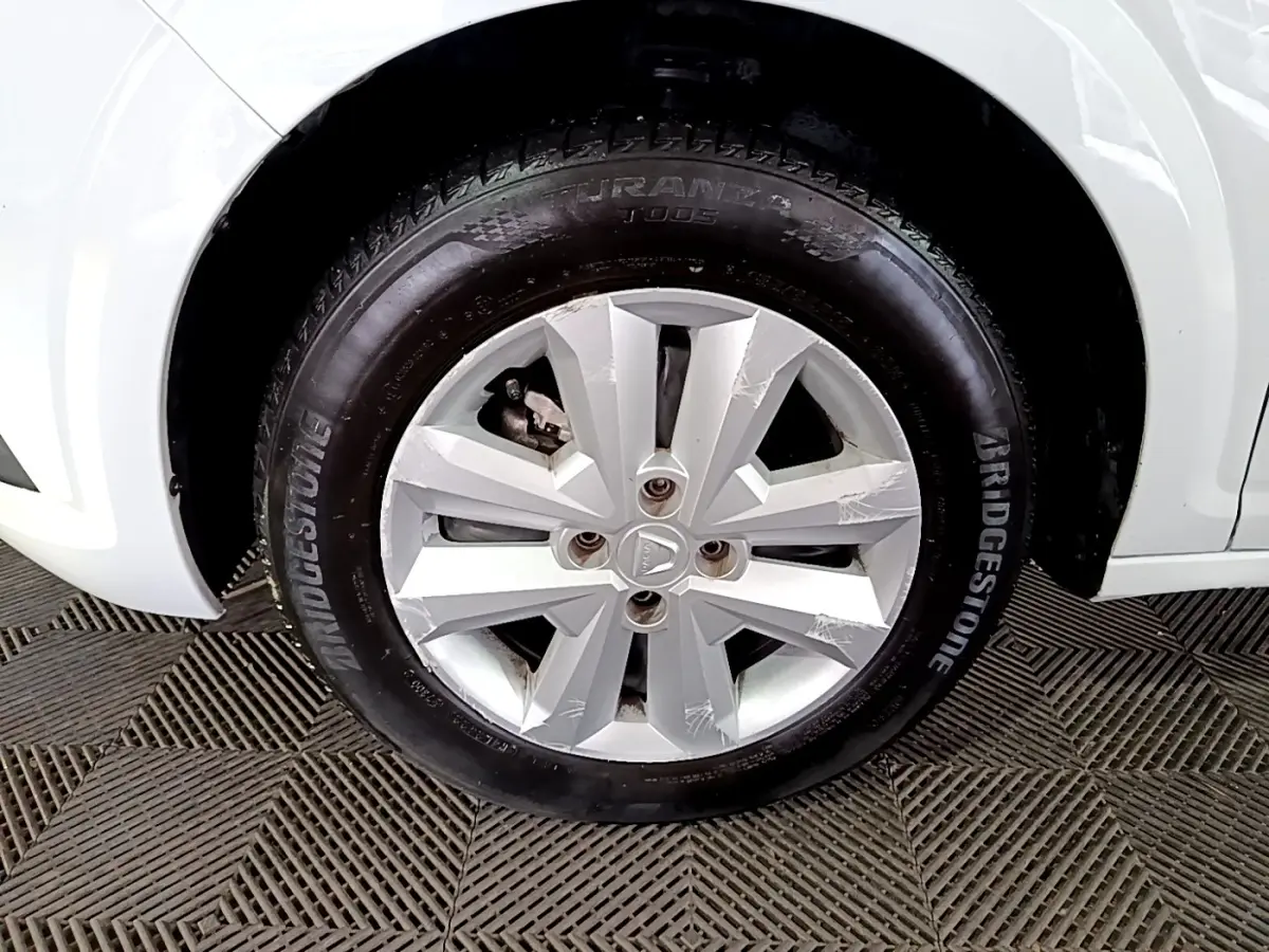 Gros plan sur la roue avant droite blanche d'une Dacia Sandero 2022 avec jante en alliage et pneu Bridgestone.