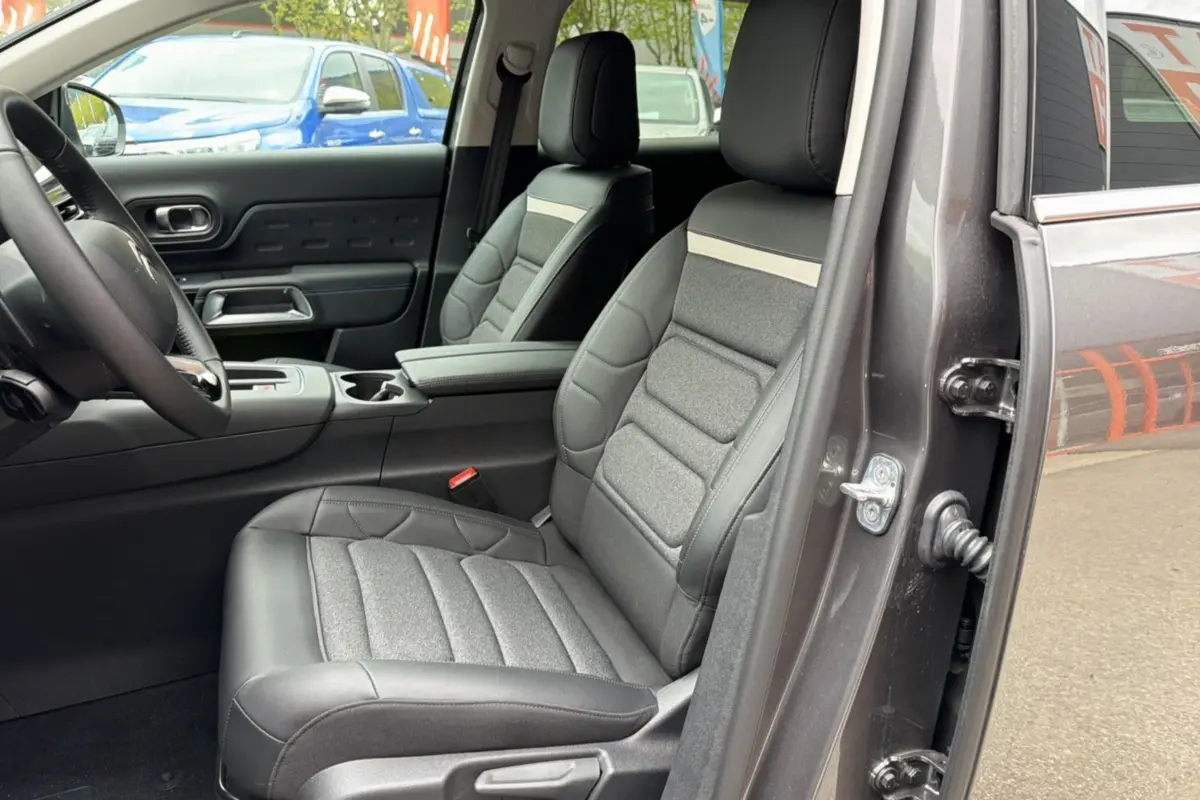 Vue intérieure côté conducteur du Citroën C5 Aircross Hybrid gris platinium, mettant en valeur les sièges Advanced Comfort et l'accoudoir central.
