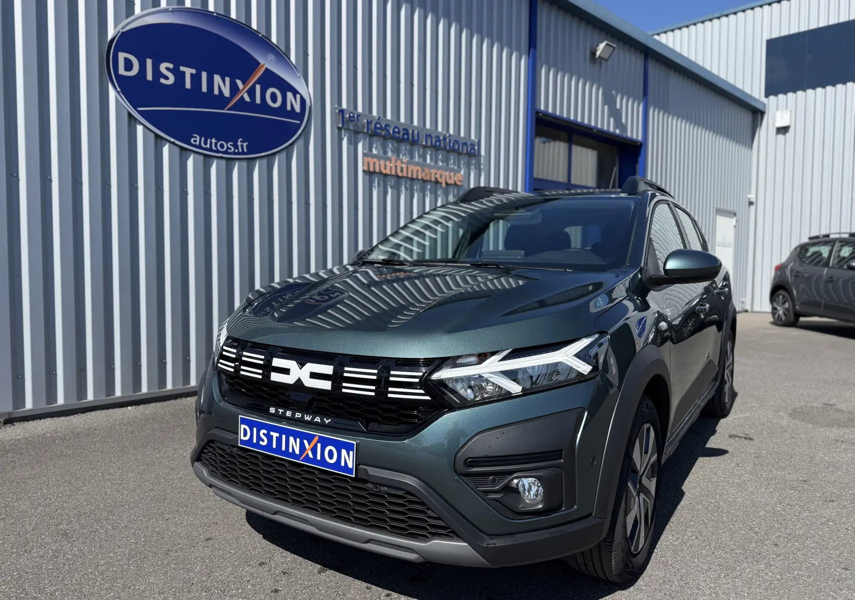 Vue 3/4 avant d'une Dacia Sandero Stepway TCE 90 ch Expression vert cèdre avec calandre noire et feux LED distinctifs.