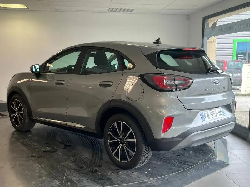 Vue 3/4 arrière droite du Ford Puma gris Solar métallisé avec jantes alu et becquet arrière en showroom.