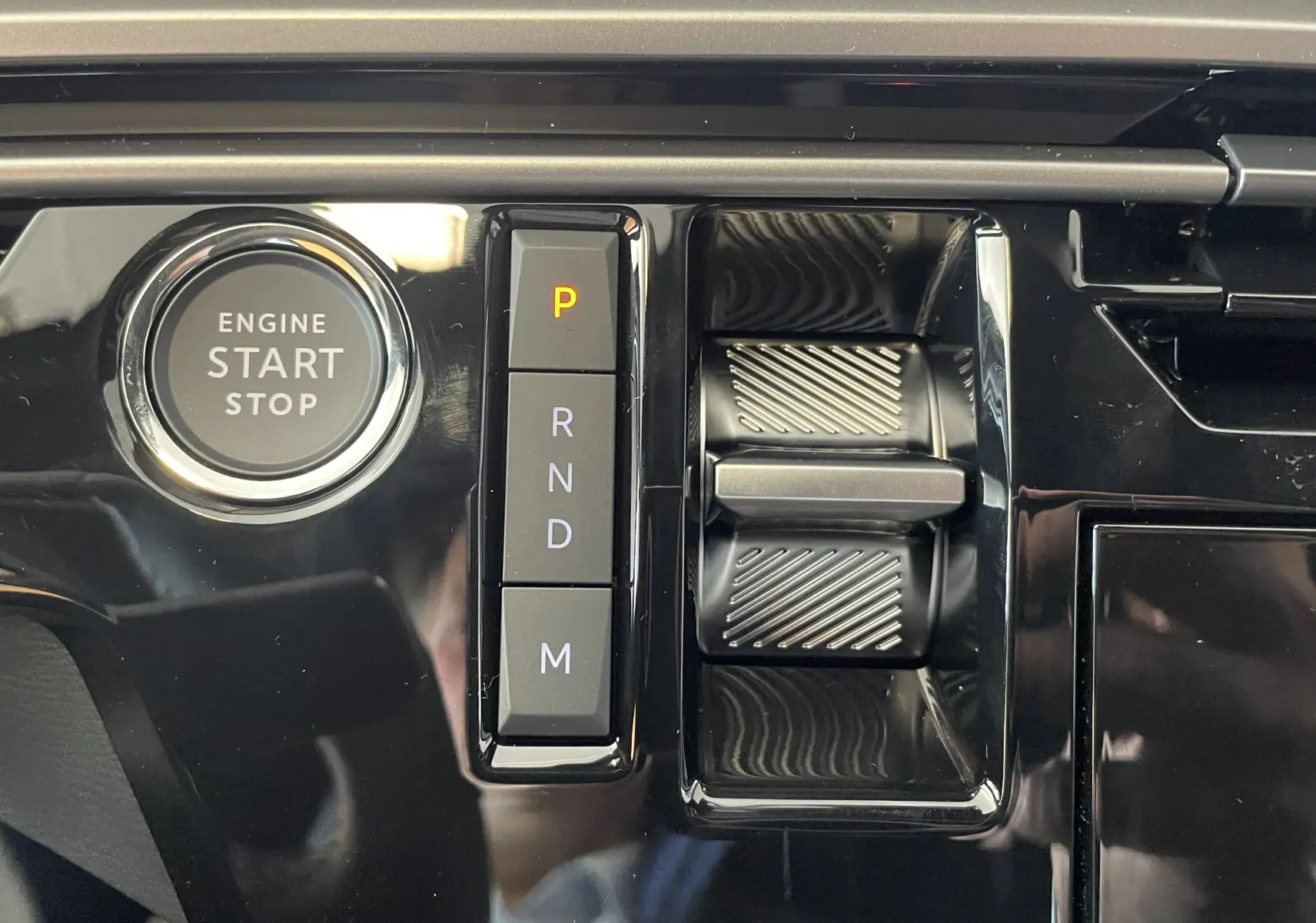 Gros plan sur la console centrale noire du Peugeot 3008 2025, avec bouton start/stop et commandes de boîte auto.