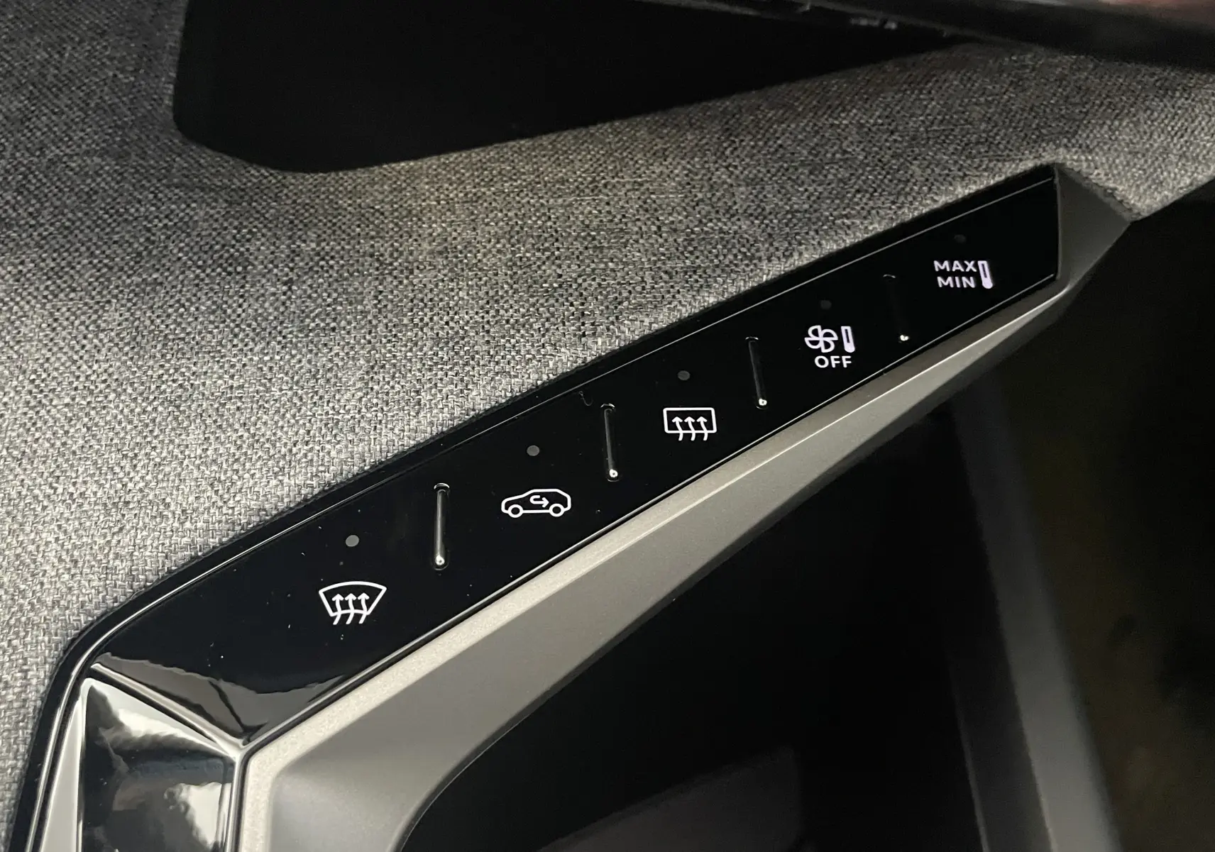 Panneau de commandes climatisation tactile du Peugeot 3008 noir 2025 avec réglages ventilation et dégivrage sur tissu gris.