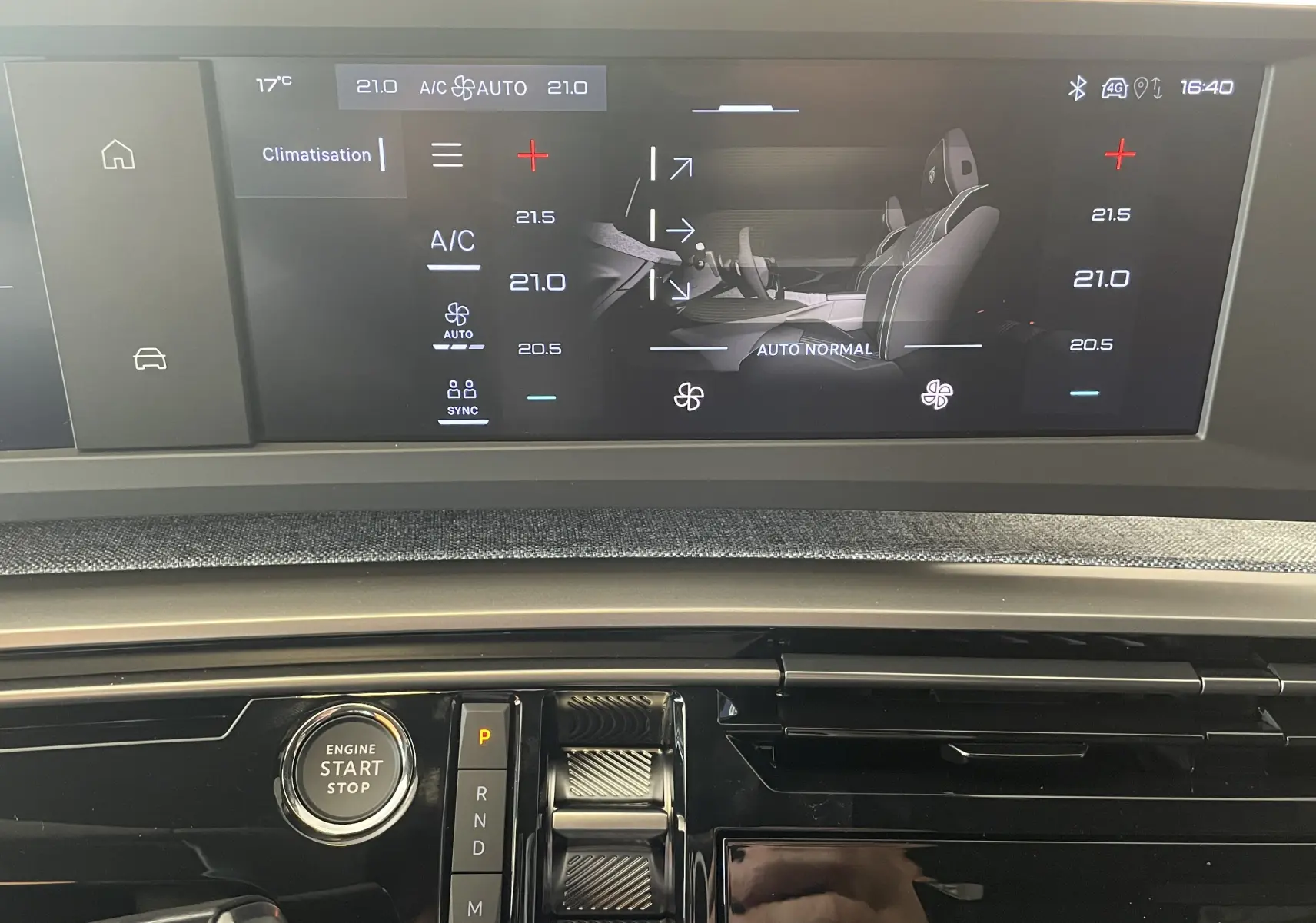 Vue rapprochée de la console centrale du Peugeot 3008 noir 2025, avec écran tactile affichant la climatisation et bouton start/stop.