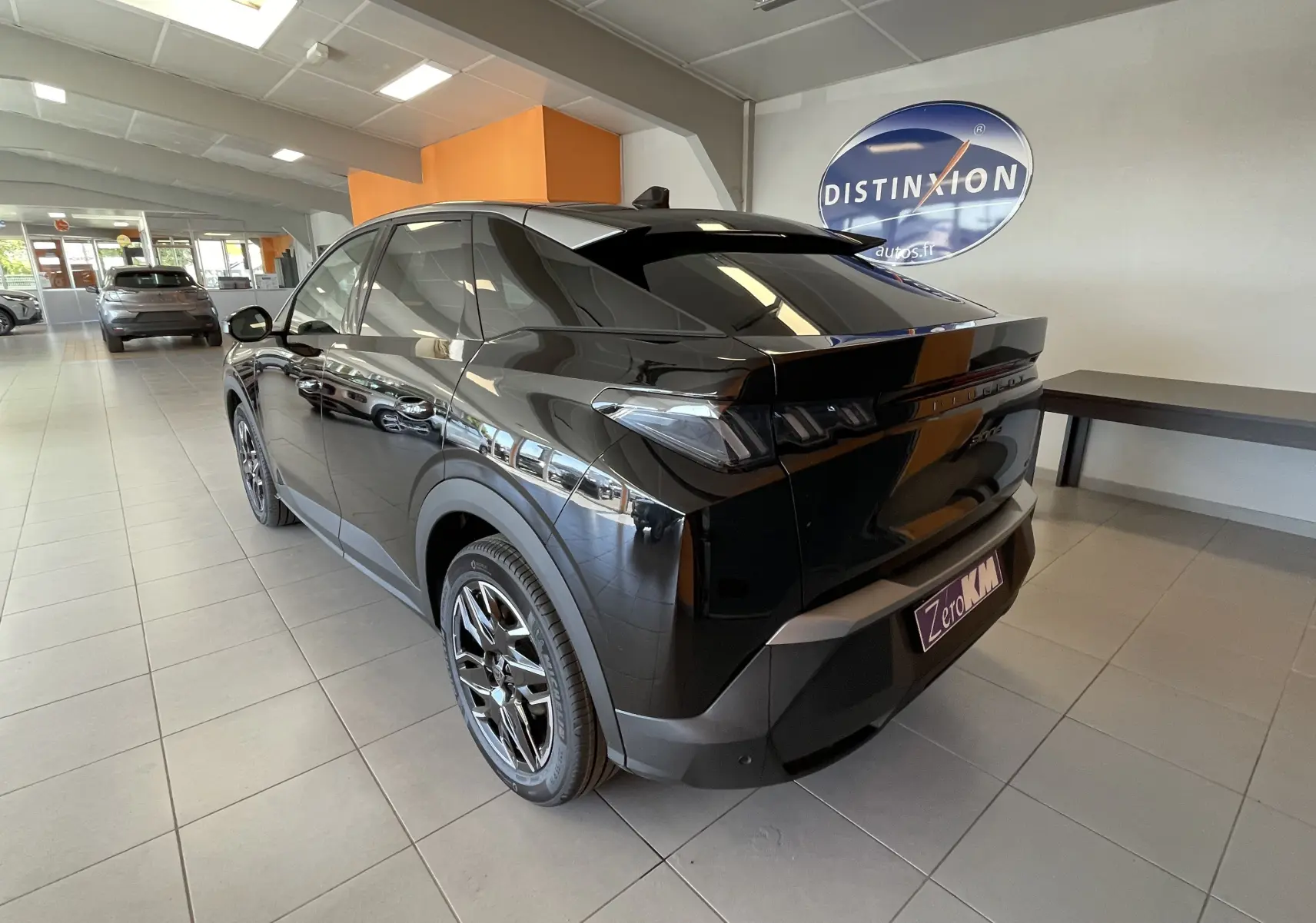 Vue 3/4 arrière droite d'un Peugeot 3008 noir 2025 avec jantes alliage diamantées dans un showroom.