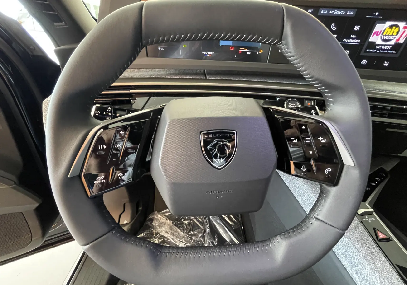 Vue rapprochée du volant cuir noir du Peugeot 3008 2025 avec commandes intégrées et tableau de bord numérique.