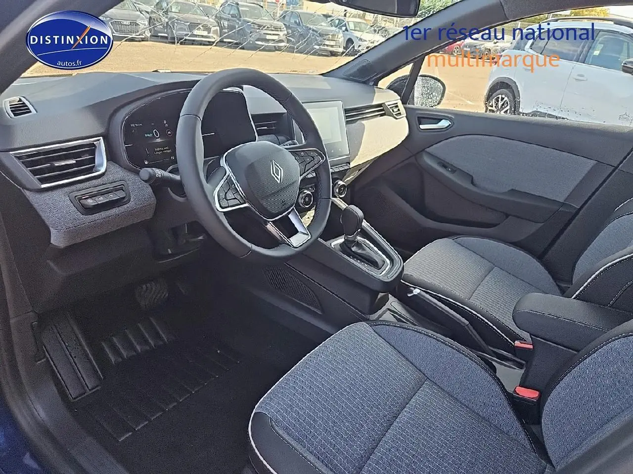 Intérieur avant de la Renault Clio V 1.6 e-tech 145 techno, sièges sport bleu et console centrale avec boîte auto.