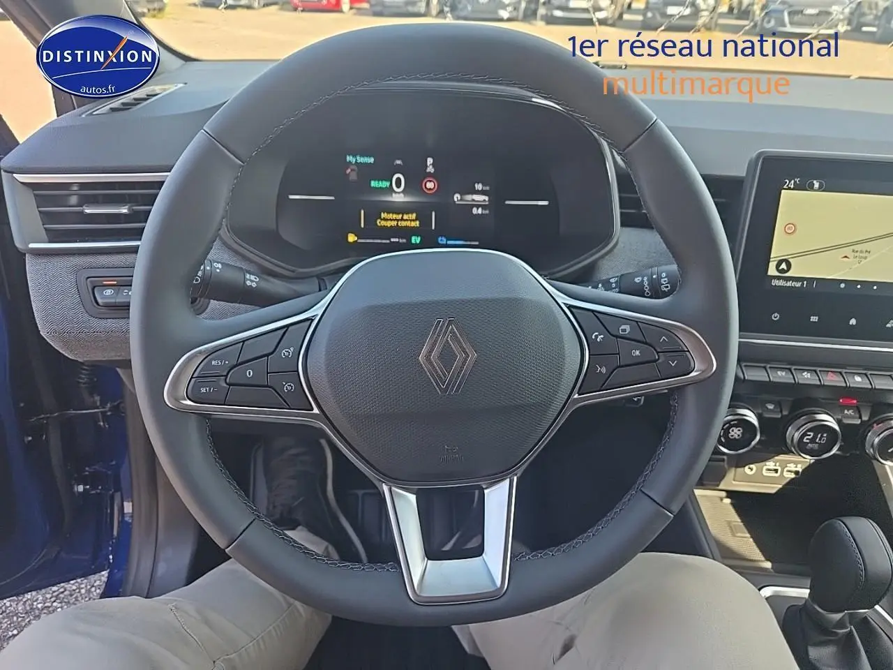Vue intérieure centrée sur le volant multifonction de la Renault Clio V bleu iron avec tableau de bord numérique et écran tactile.