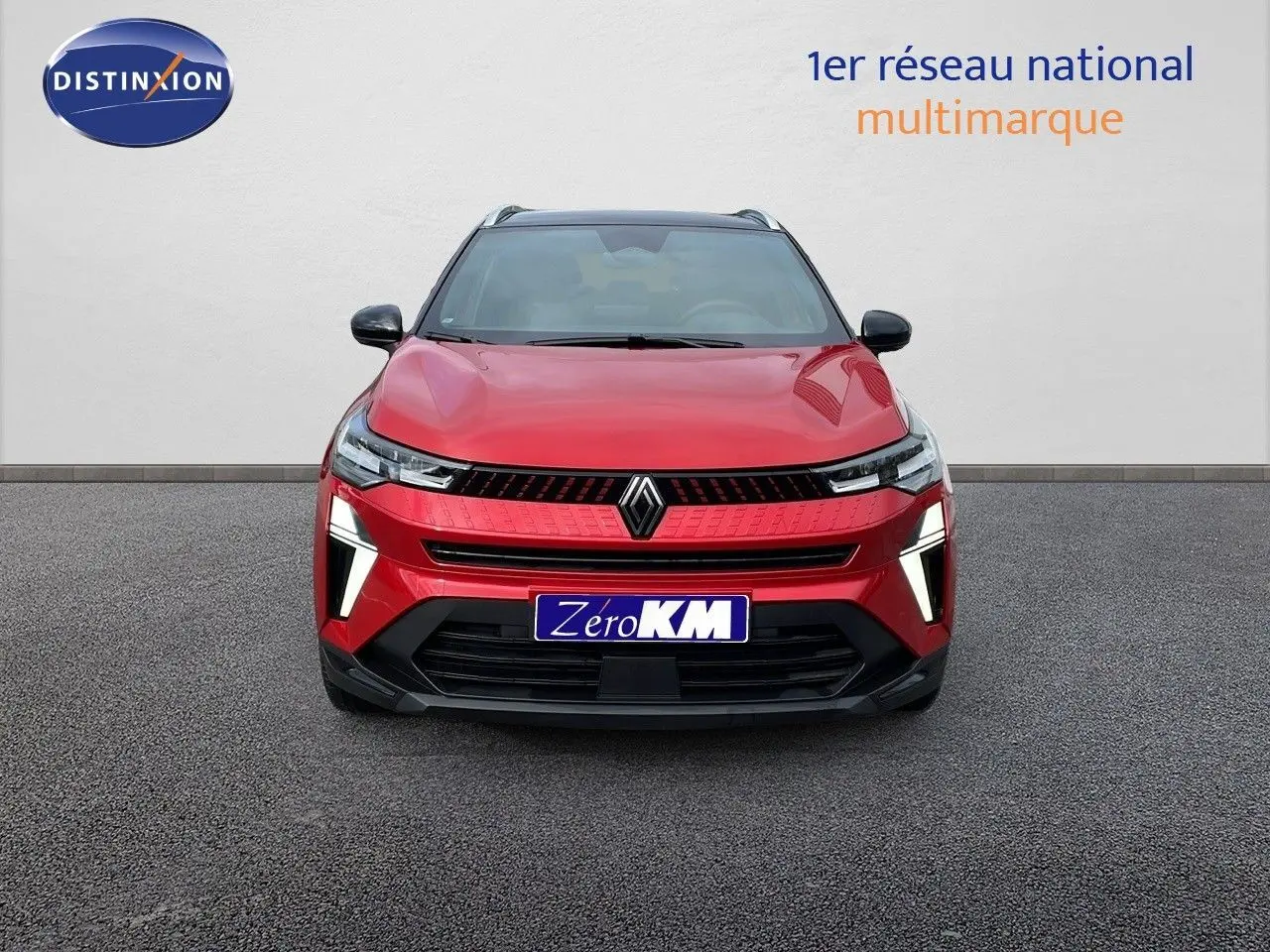 Vue frontale du Renault Captur E-Tech Hybrid 2025 rouge passion avec toit noir, éclairage LED distinctif allumé.