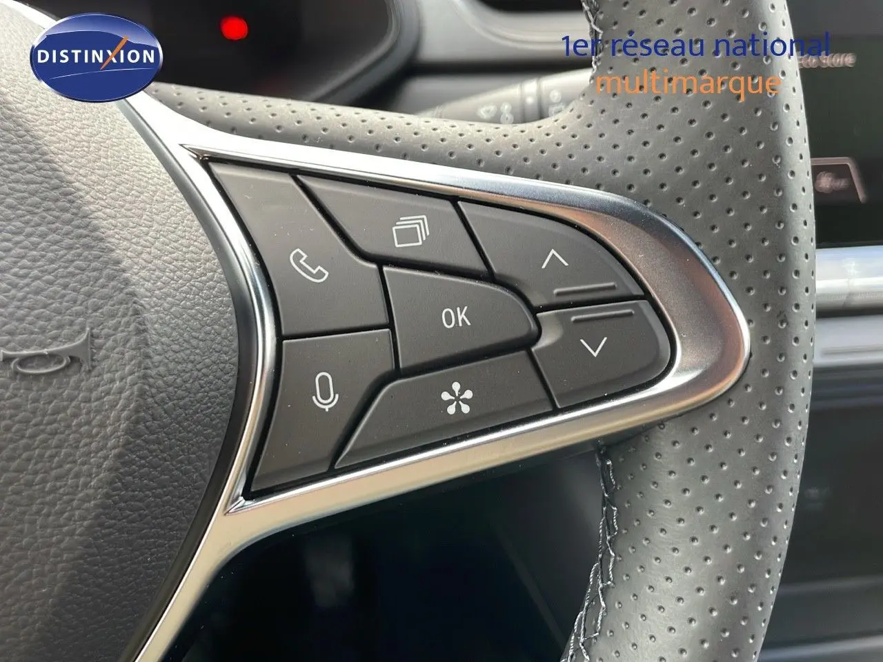 Gros plan sur les commandes multifonctions à droite du volant perforé du Renault Captur E-Tech hybride 2025.