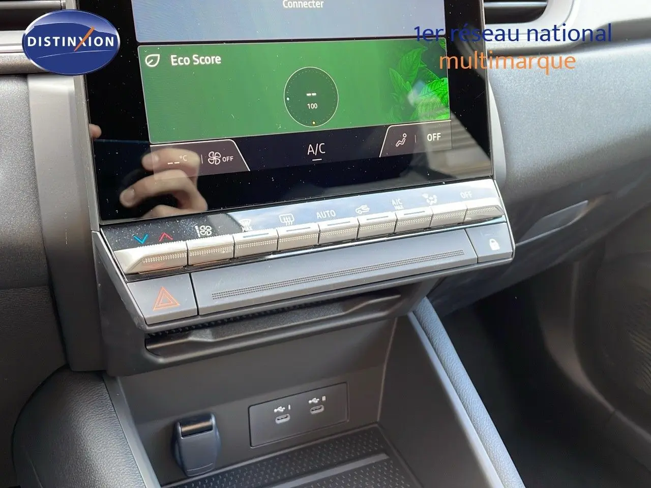 Vue rapprochée de la console centrale du Renault Captur E-Tech hybride 2025 avec écran tactile et commandes climatisation.