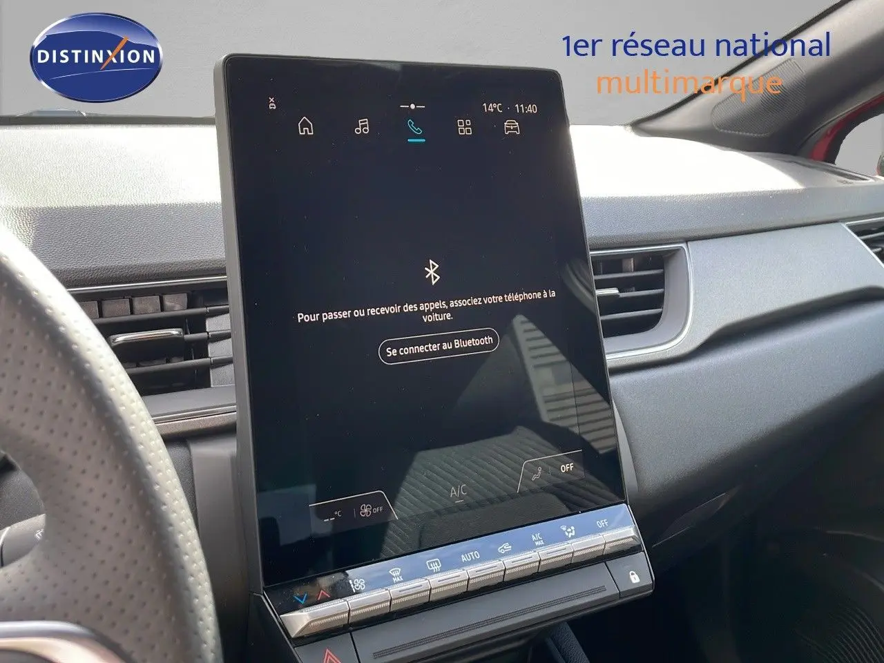Écran tactile central du tableau de bord du Renault Captur E-Tech rouge, avec commandes climatisation visibles.