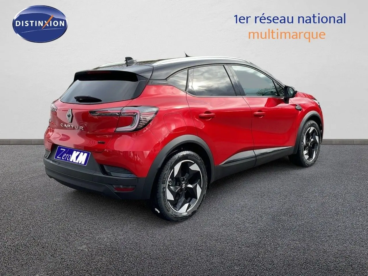 Vue 3/4 arrière droite d'un Renault Captur E-Tech hybride rouge passion avec toit noir et jantes noires.