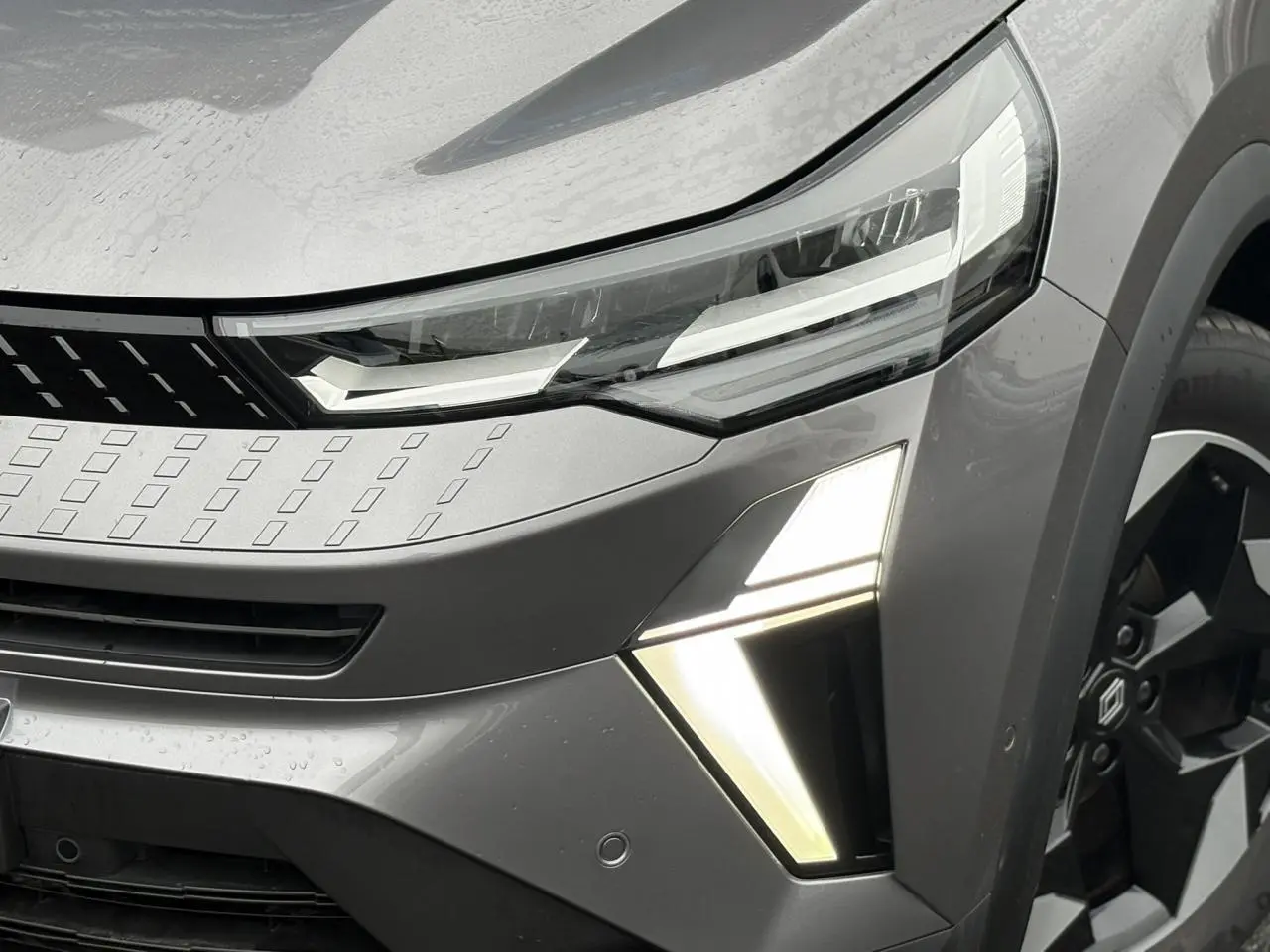 Gros plan sur l'avant droit du Renault Captur gris Cassiopée avec feux LED et jante alu noire diamantée.