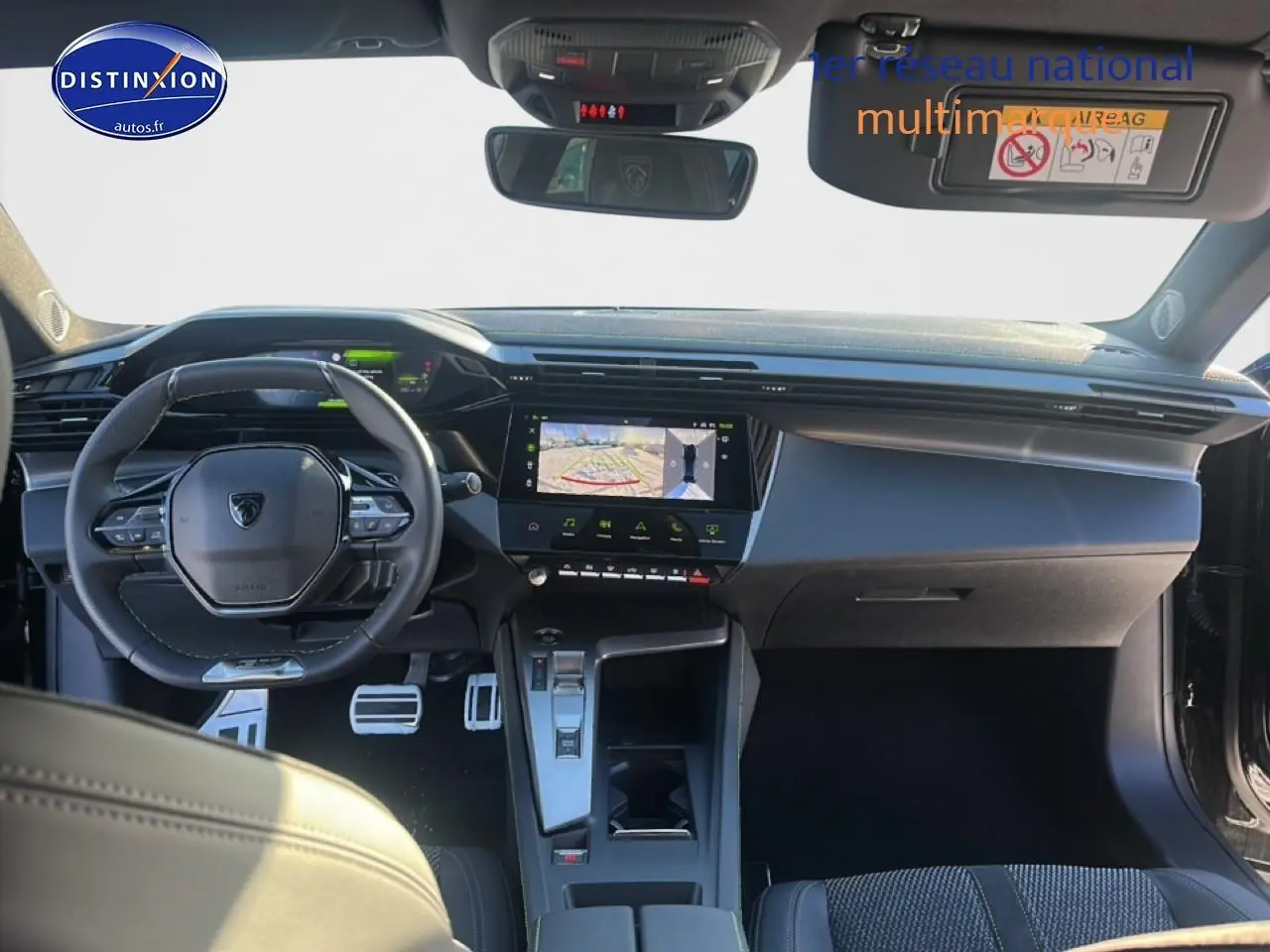 Vue intérieure avant du Peugeot 408 Hybrid 145 GT noir, avec tableau de bord numérique et écran tactile central affichant la caméra de recul.