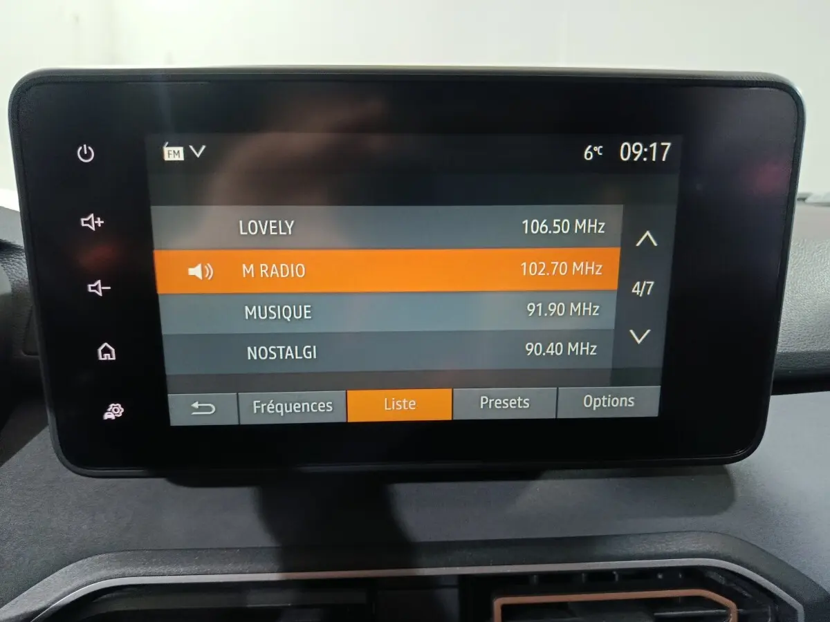 Écran tactile central de la Dacia Sandero 2024 affichant la liste des radios FM avec sélection sur M Radio.