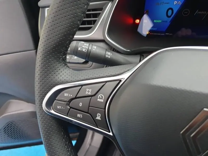 Gros plan sur le volant noir perforé de la Renault SYMBIOZ 2025, avec commandes multifonctions et tableau de bord digital partiel.