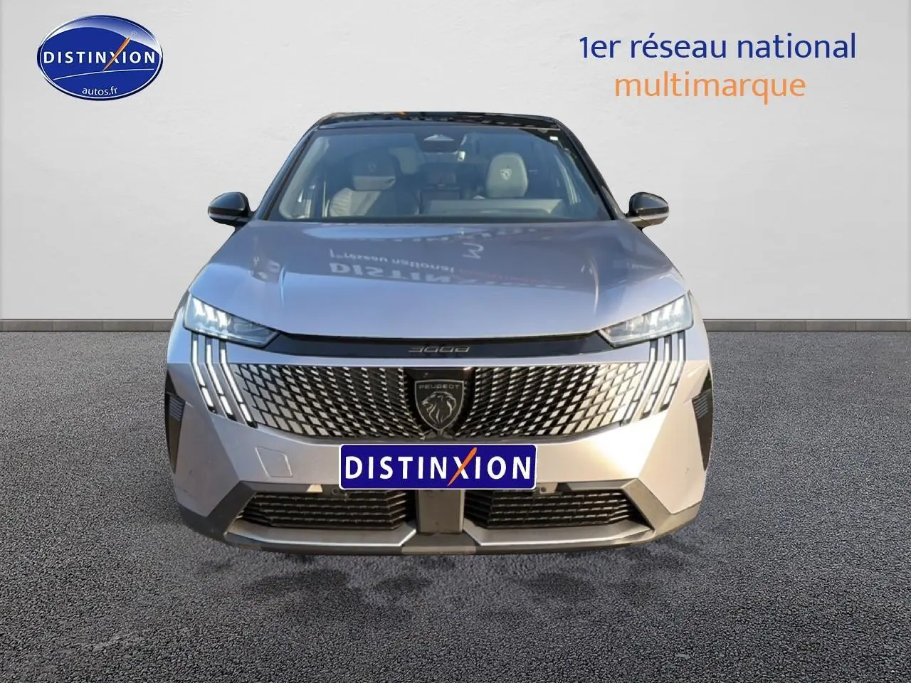 Vue frontale d’un Peugeot 3008 gris 2025 avec calandre distinctive et phares LED fins allumés.