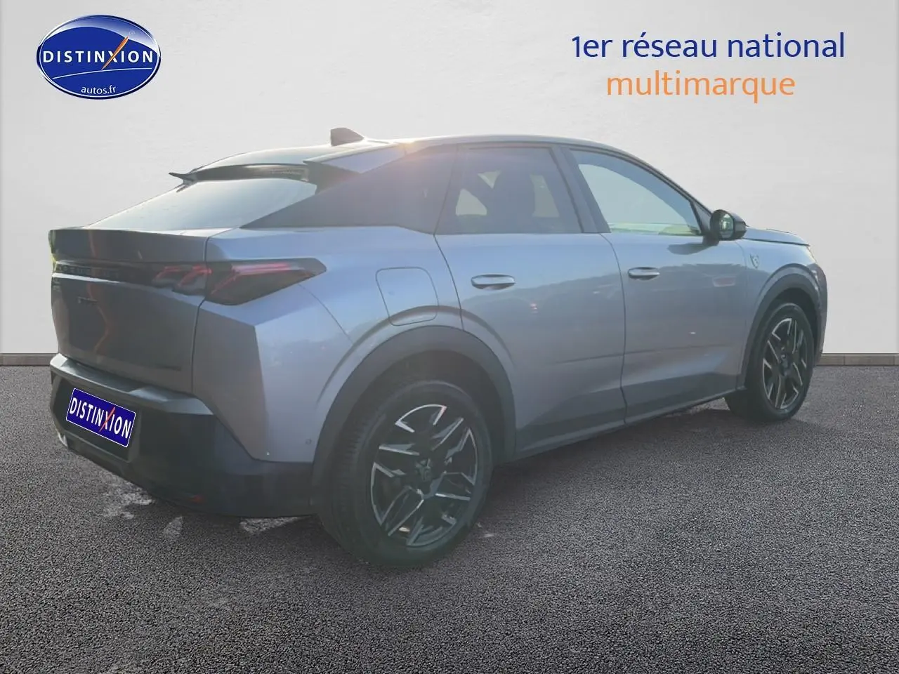 Vue 3/4 arrière droite d’un Peugeot 3008 gris 2025 avec jantes alu noires et becquet arrière visible.