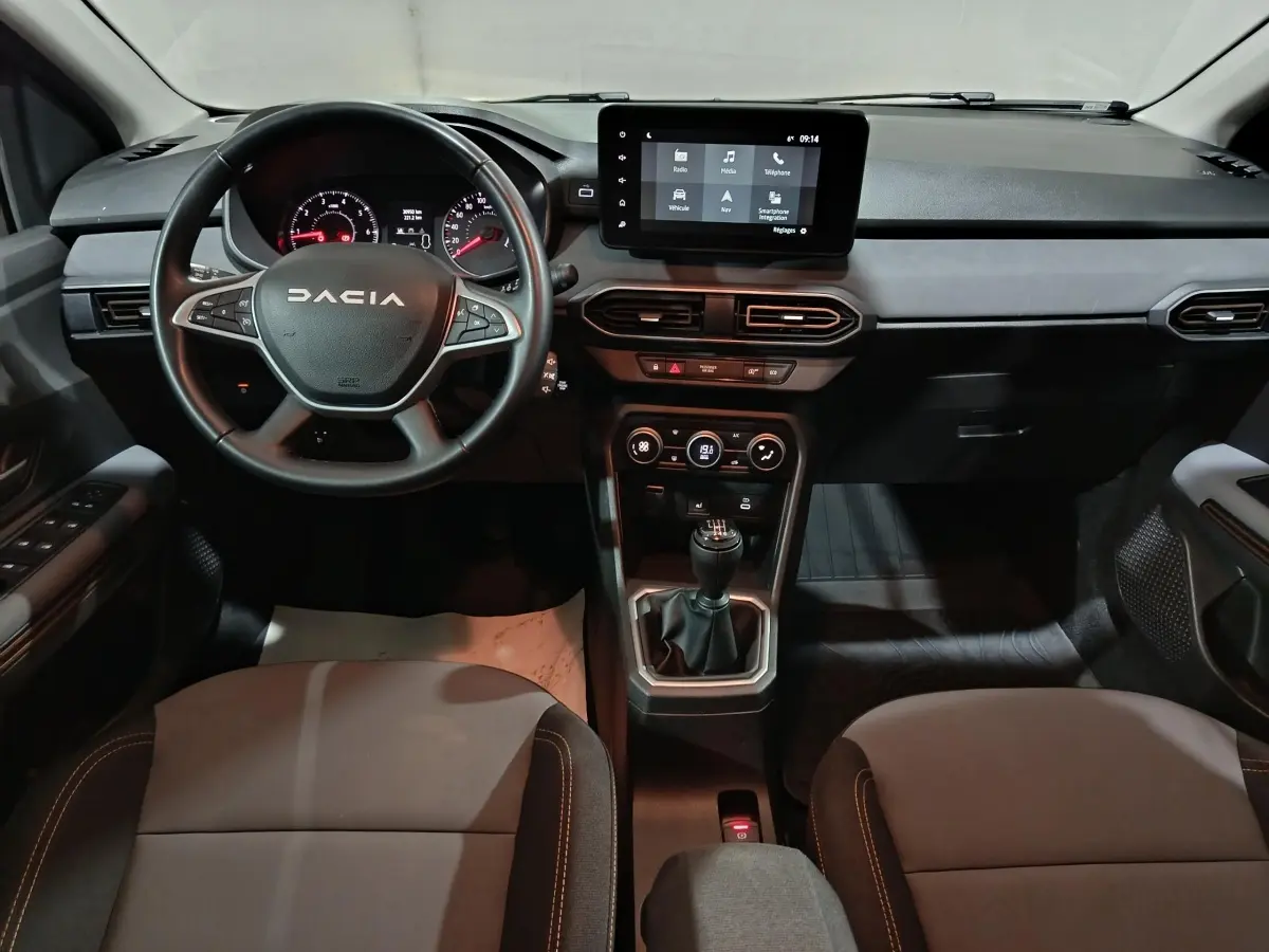 Vue intérieure du tableau de bord et volant cuir noir de la Dacia Sandero Extreme+ 2024 avec écran tactile central.