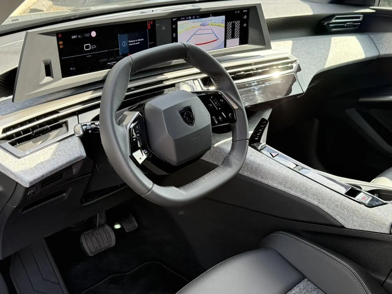 Intérieur du Peugeot 3008 Hybrid 145 e-DSC6 Allure 2025, vue du poste de conduite avec volant compact et double écran panoramique.