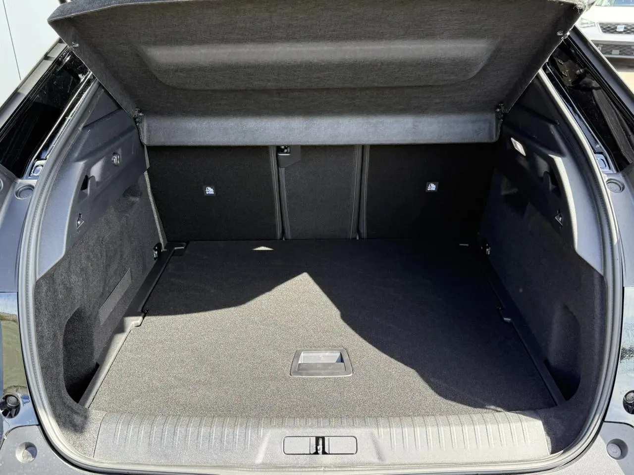 Coffre ouvert du Peugeot 3008 Hybrid 145 Allure noir Perla, montrant un plancher modulable et un intérieur spacieux.