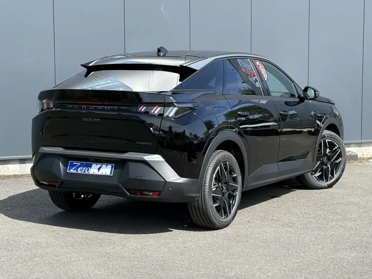 Peugeot 3008 Hybrid noir Perla en 3/4 arrière droit, avec jantes alliage noires et feux arrière LED griffés.