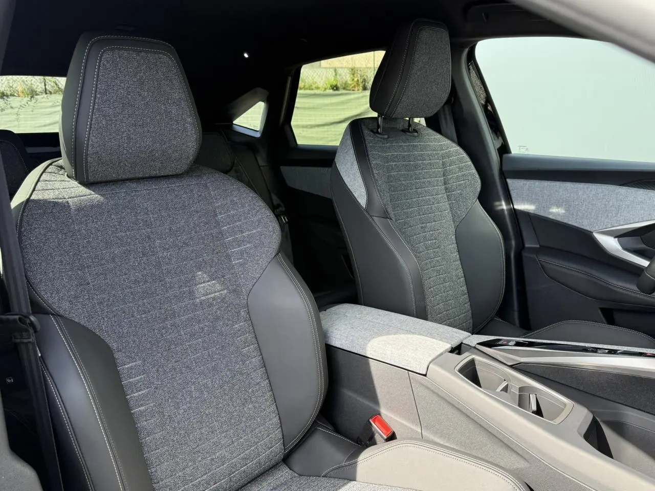 Vue rapprochée des sièges avant en tissu gris et cuir noir du Peugeot 3008 Hybrid 145 e-DSC6 Allure 2025.