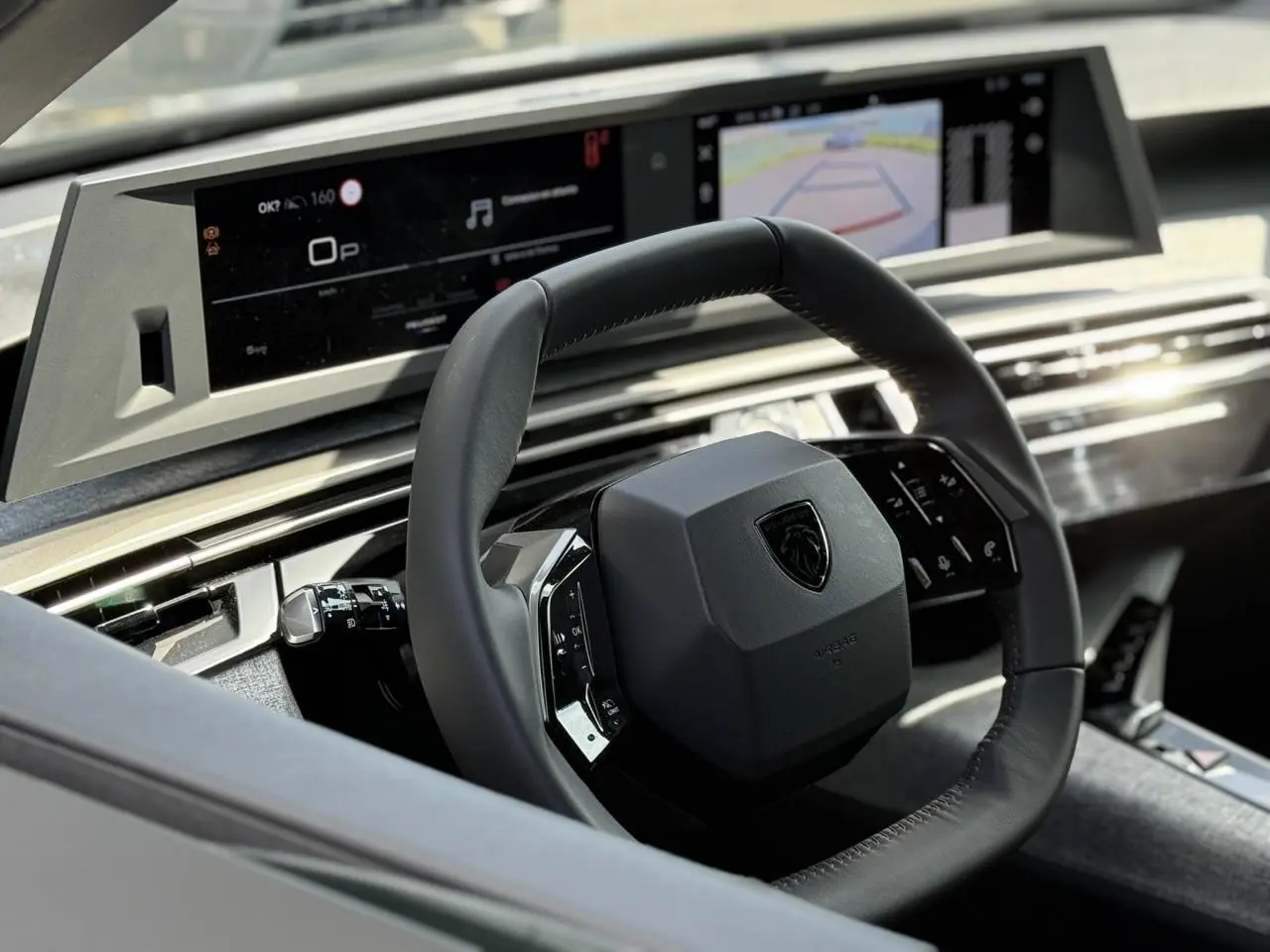 Vue intérieure rapprochée du volant cuir noir et du tableau de bord numérique du Peugeot 3008 Hybrid 2025.
