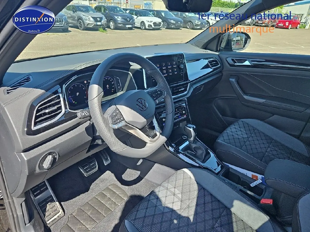 Intérieur du Volkswagen T-Roc 2025 vu côté conducteur, volant cuir multifonction et sièges tissu R-Line noirs.