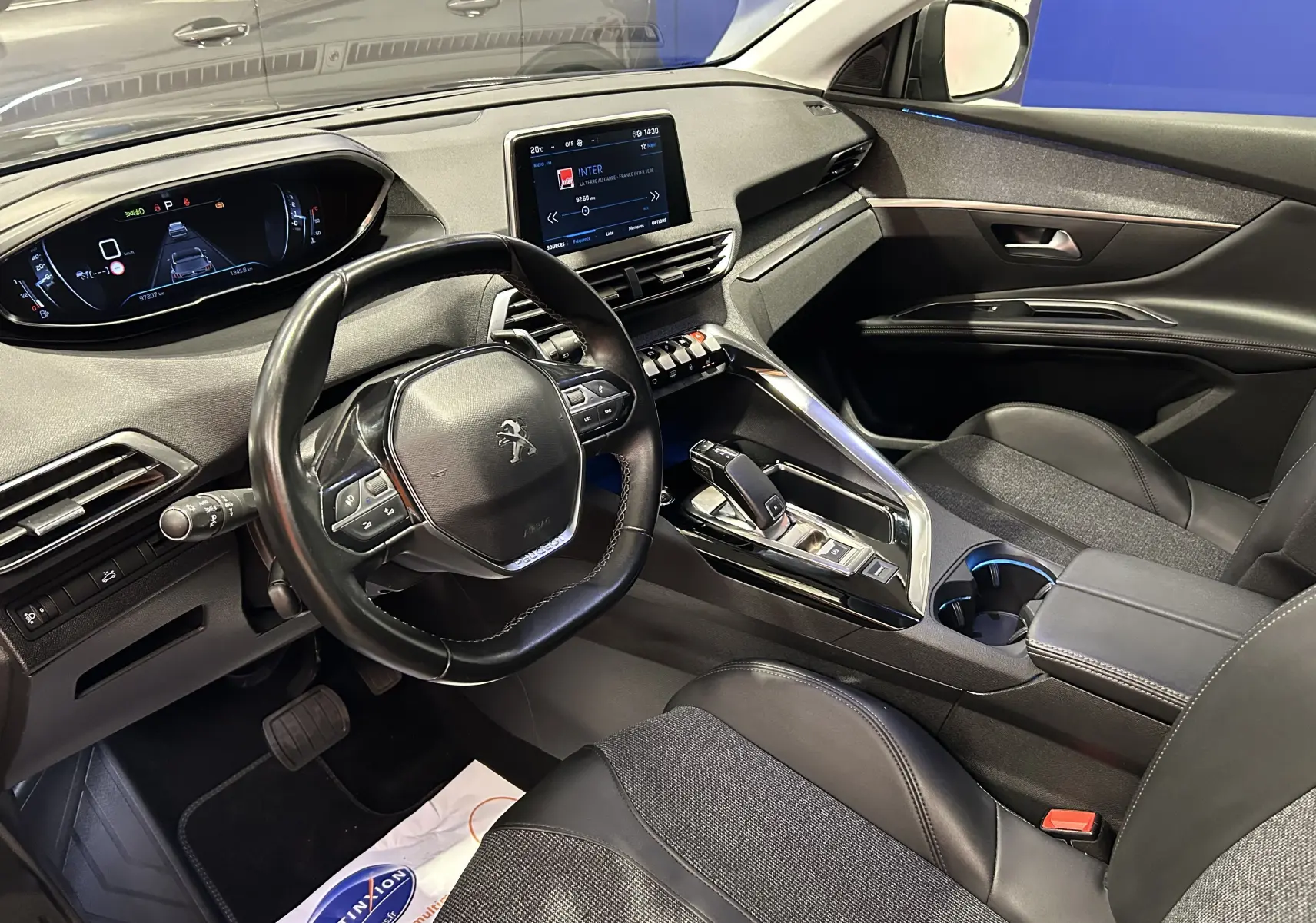 Intérieur du Peugeot 5008 gris 2020, vue côté conducteur montrant le tableau de bord et la console centrale moderne.