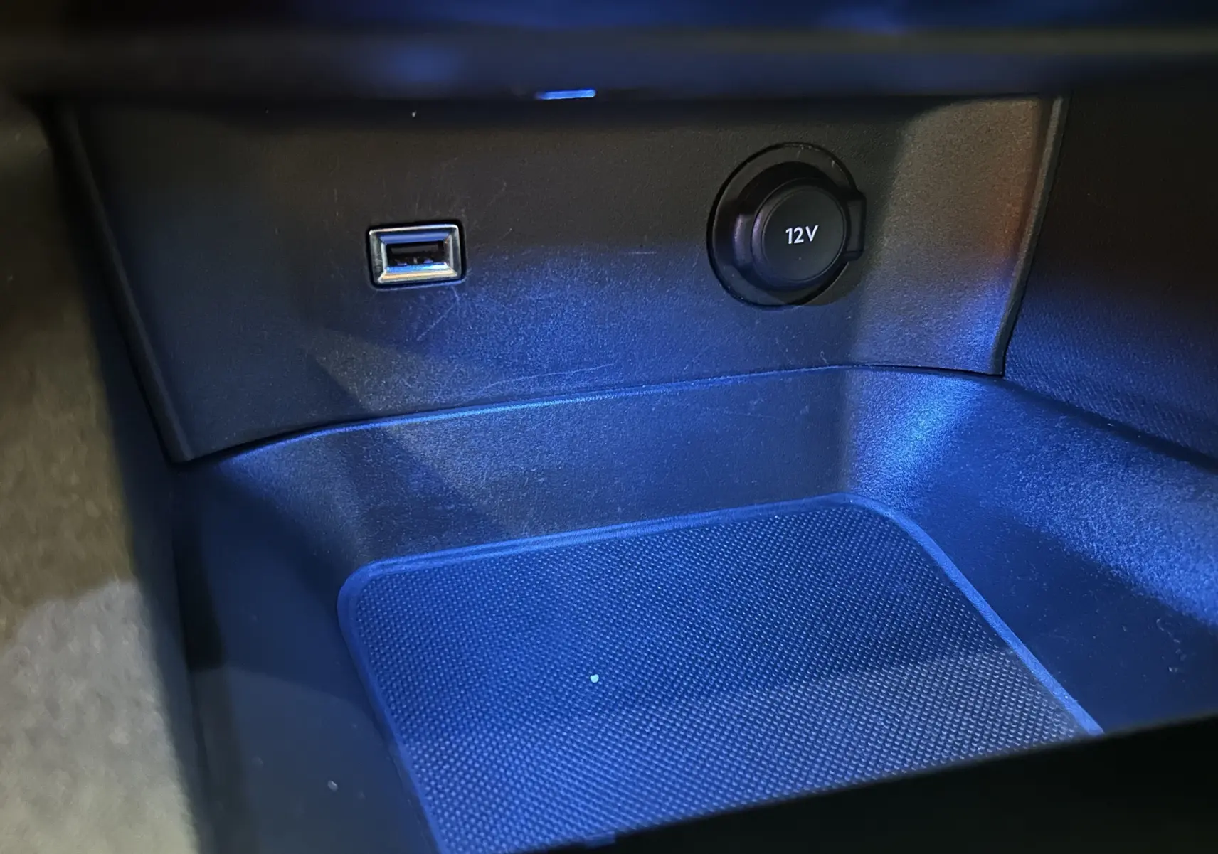 Gros plan sur la prise 12V et port USB dans l'habitacle du Peugeot 5008 gris, version BlueHDi 130 EAT8 Allure.