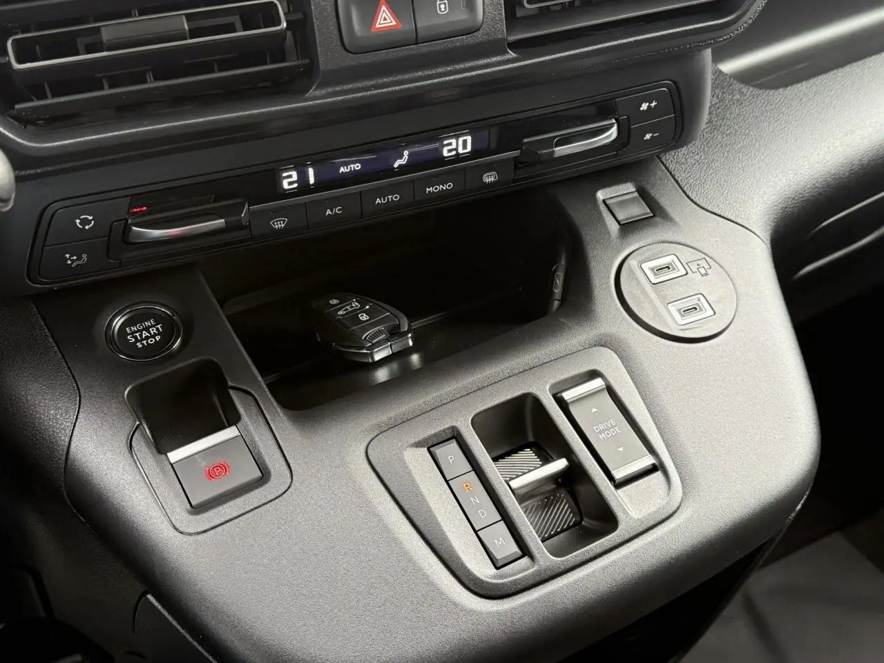 Vue rapprochée de la console centrale noire du Peugeot Partner 2025 avec commandes de boîte auto et démarrage sans clé.