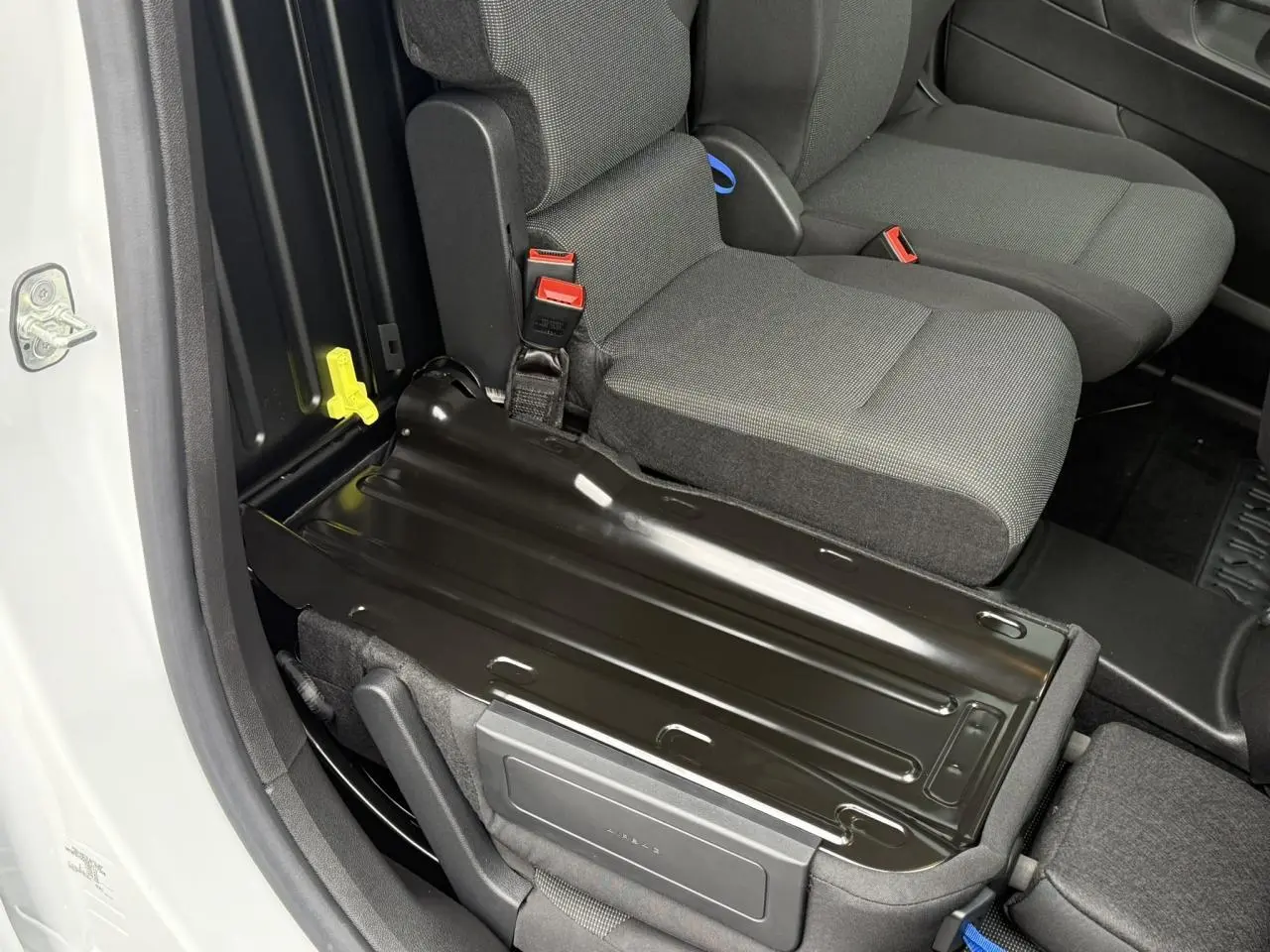 Détail de la banquette passager rabattue côté droit dans l'habitacle gris du Peugeot Partner blanc 2025